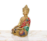 Brass Buddha statue side view, seated pose, multicolor jeweled robe and gold details