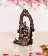 Copper Ganesha murti idol statue, side view with decorative arch backdrop
