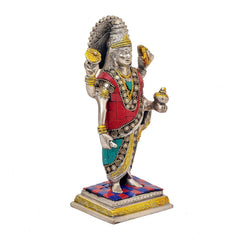 Dhanvantari brass statue, side view; red robe and teal sash with detailed circular ornaments.