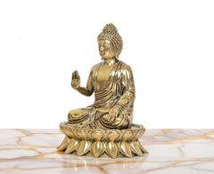 Brass Buddha statue seated on lotus base, Abhaya mudra gesture, side view