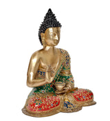 Seated Buddha statue, three-quarter view, gold torso with green robe and red cushion.