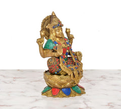 Lakshmi goddess brass idol on lotus base, raised arms, multicolored decorative details