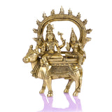 Brass Shiva Parvati idol seated on Nandi with ornate halo arch