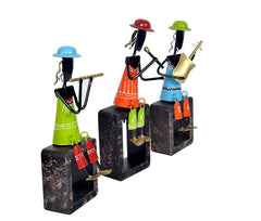 Angled view of Iron Musician set: three figurines holding instruments on dark block bases