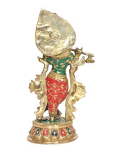 Brass Krishna playing flute idol statue, rear view with large blue skirt patterns and ornaments.