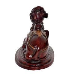 Back view of seated Nandi bull statue, dark brown glossy finish with gold trim