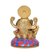 Back view of brass Lakshmi figurine with blue-red jeweled skirt