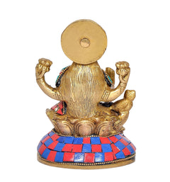 Back view of brass Lakshmi figurine with blue-red jeweled skirt