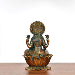 Lakshmi brass idol back view with detailed halo and teal draped garment on lotus