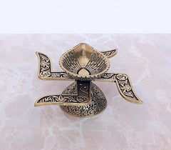Brass diya oil lamp with ornate swastik-style frame and textured bowl
