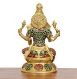Lakshmi statue from back, circular halo on head, red-green jeweled dress and arms