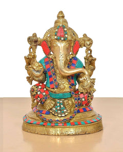 Brass Lord Ganesha idol front view with jeweled crown, red/teal ornaments, and gold frame.