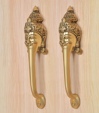 Golden brass long-neck handles with ornate head backplates and curved lever grips