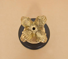 Brass Ashoka figurine top view on revolving dark base, showing animal legs and feet