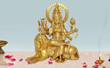 Brass Durga statue sitting on lion, holding weapons and trident