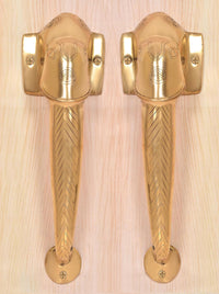 Golden brass Ganesha face door handles with square wall plates and chevron lever grip