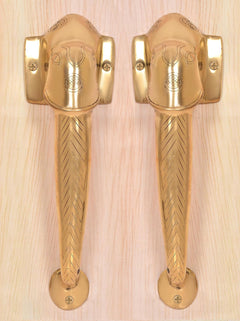 Golden brass Ganesha face door handles with square wall plates and chevron lever grip