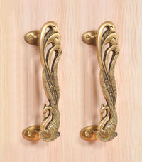 Golden brass door handle pair with peacock-and-feather engravings and side mounting