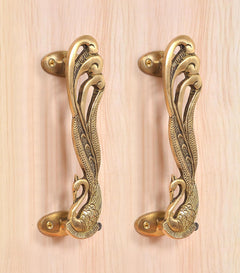 Golden brass door handle pair with peacock-and-feather engravings and side mounting