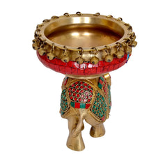 Brass elephant statue with red urli bowl and multicolor patterned panels