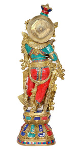 Brass Radha idol statue with round halo behind, red skirt and teal accents on gold base