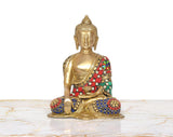 Brass Buddha statue, close front view, multicolor jeweled robe on seated body