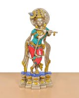 Standing Krishna idol playing flute, brass tone with blue chest and red patterned pants