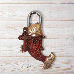 Antique fish-shaped padlock with red scale body, brass top, arched shackle, keys