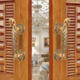 Brass peacock design door handle pair with round rosettes on a door