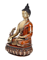 Buddha statue in profile, brass finish with orange draped robe and lotus pedestal