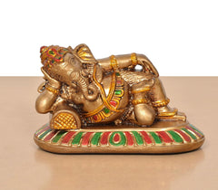 Close-up of relaxing Ganesha resin statue with striped base in red, green, white