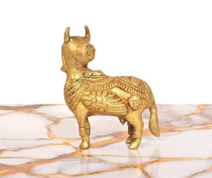 Brass Kamdhenu cow figurine, golden finish, front-right profile with patterned body
