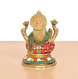 Brass Lakshmi idol statue back view, gold textured panel and multicolor belt ornaments.