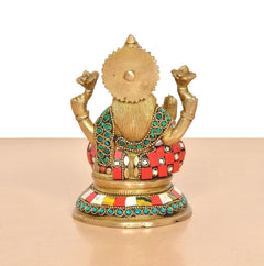 Brass Lakshmi idol statue back view, gold textured panel and multicolor belt ornaments.