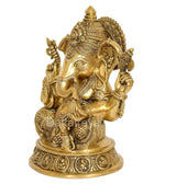Golden brass Ganesha statue in profile, seated with decorative headdress and arms