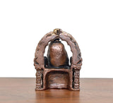 Copper Shirdi Sai Baba idol, close-up front, arched backdrop and patterned pedestal