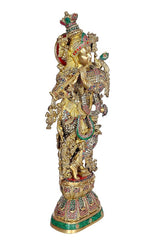 Brass Krishna statue three-quarter view, ornate jewelry and crown, flute held outward