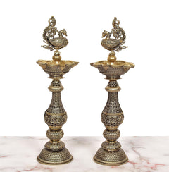 Ornate brass peacock oil lamps set of 2 with engraved detailing on stems and bases.