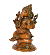 Brass Ganesha idol side view, seated posture with raised hands and green detailing