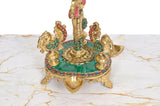 Brass peacock oil lamp base with teal inlay, gold trim, and three diya cups