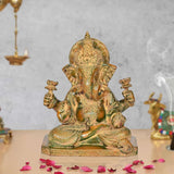 Brass Ganesha idol, four hands raised, ornate crown, seated on pedestal