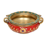 Empty brass urli with red body, gold rim, blue bead trim, and side handles