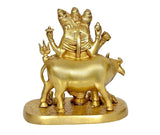 Back view of brass cow-riding Trimurti idol, ornate headdress, on round base