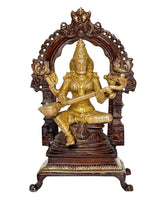 Seated Saraswati brass idol facing forward, arched backrest with detailed carvings