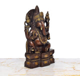 Ganesha brass idol, three-quarter view, raised trunk and gilded patterns