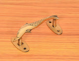 Golden brass dolphin fish door pull with two screw plates on a wooden door