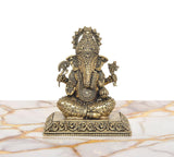 Seated Lord Ganesha brass idol with patterned torso, trunk detail, and decorative pedestal.