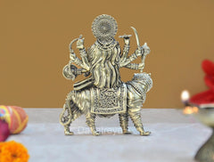 Back view of brass Durga Maa idol on lion, ornate crown and flowing garments