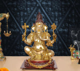 Brass Ganpati Bappa idol with gold body, red crown, four arms, on decorated base