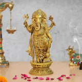 Brass standing Lord Ganesha idol with raised arms, round ornate base